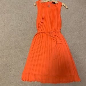Coral orange, pleated below knee sun dress from Banana Republic.